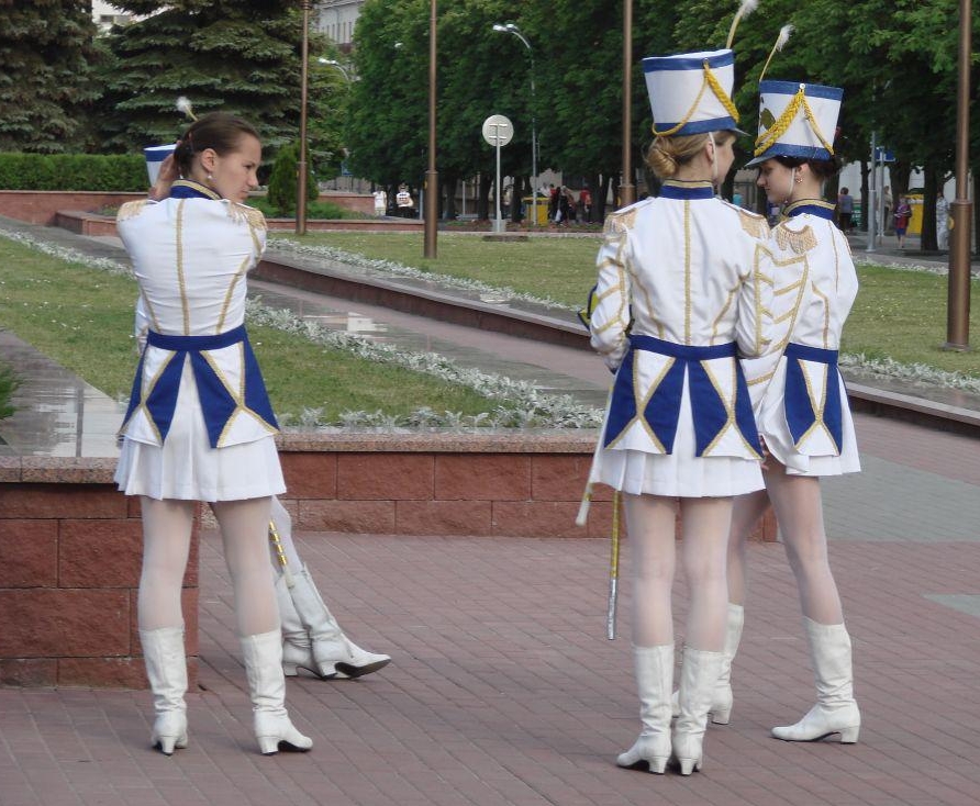 Four Majorettes wearing White Opaque Pantyhose and White Pleated Miniskirts